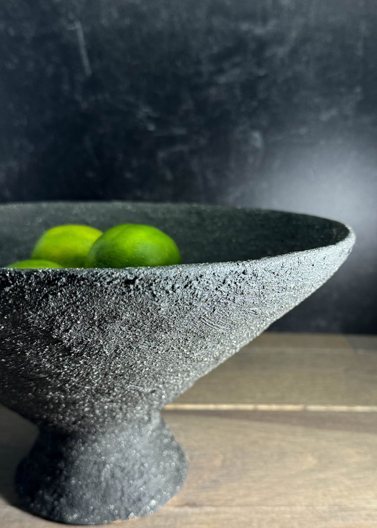 The Black Sands pedestal bowl is built from individual coils of clay and decorated with a heavily textured black slip. Specks of white can be seen throughout the rocky  crackled texture  which is inspired by Iceland’s black sand beaches. It has been sanded to a finish that begs to be touched.