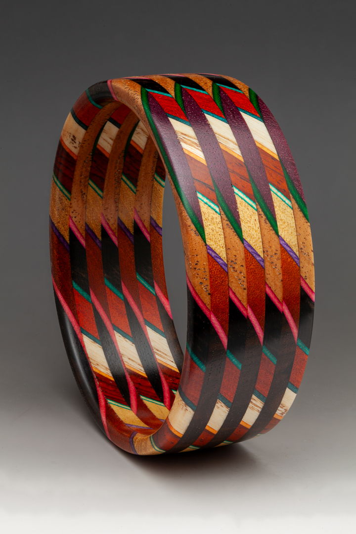 Part of the "Unbound" Series  the laminate is cut on a 45 degree angle and then the slices are stacked and orientated in a 90 degree rotation. The exotic and domestic hardwoods are sustainably sourced throughout the world  accented with dyed Maple veneer. 225 individual pieces