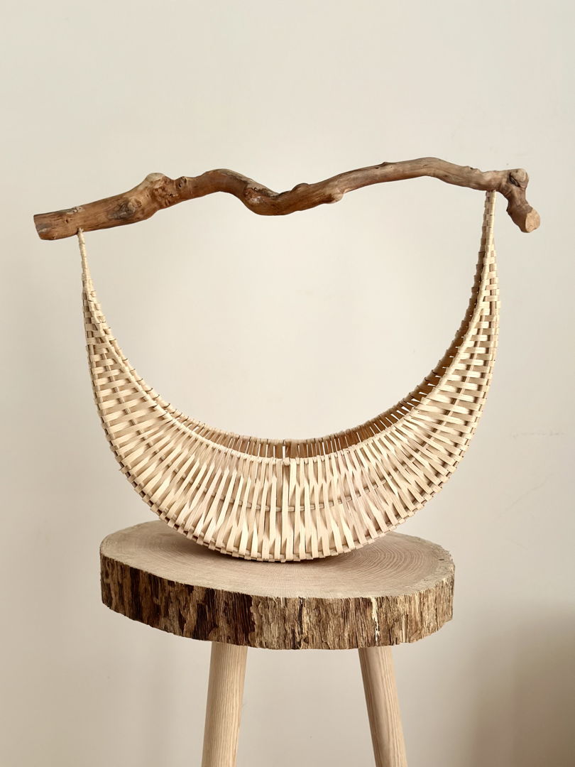 U-shaped basket with white weave and dark driftwood handle
