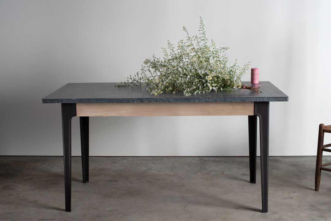 A smart kitchen prep table with a soapstone top  maple apron and cast iron legs.