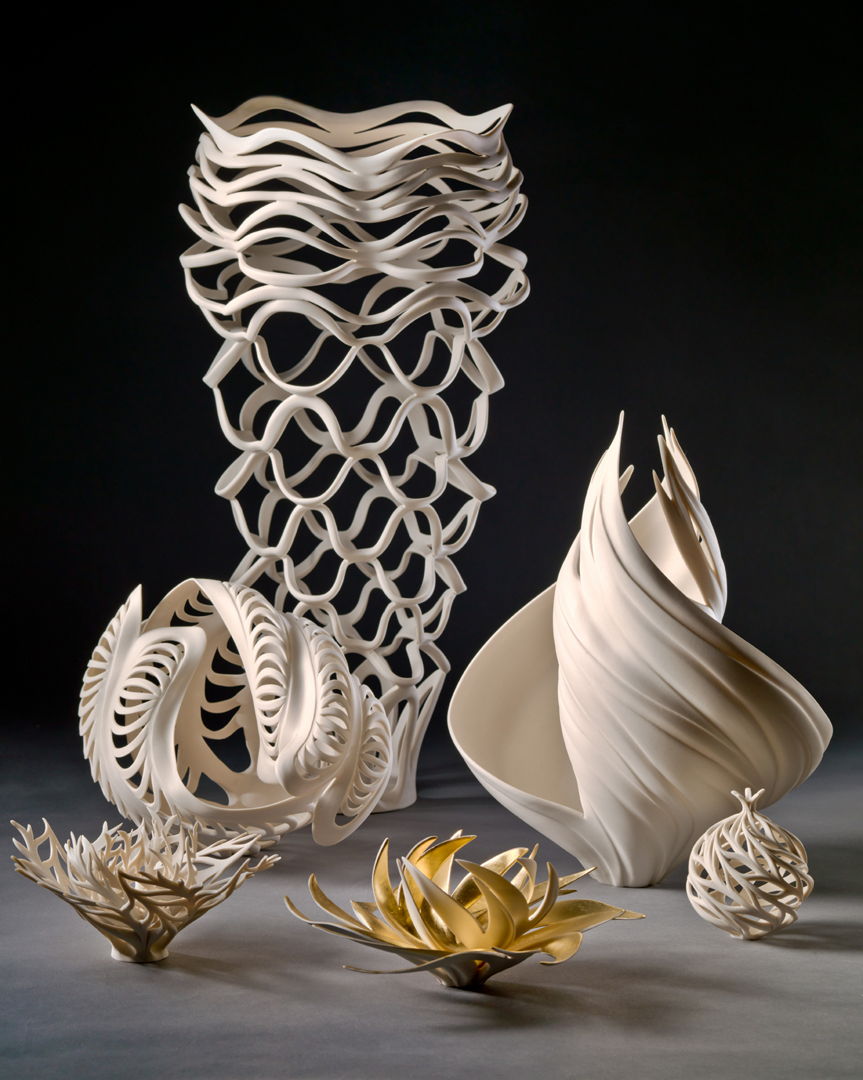 Group of  twisting porcelain  forms that have been carved. Some are accented with gold gilding.