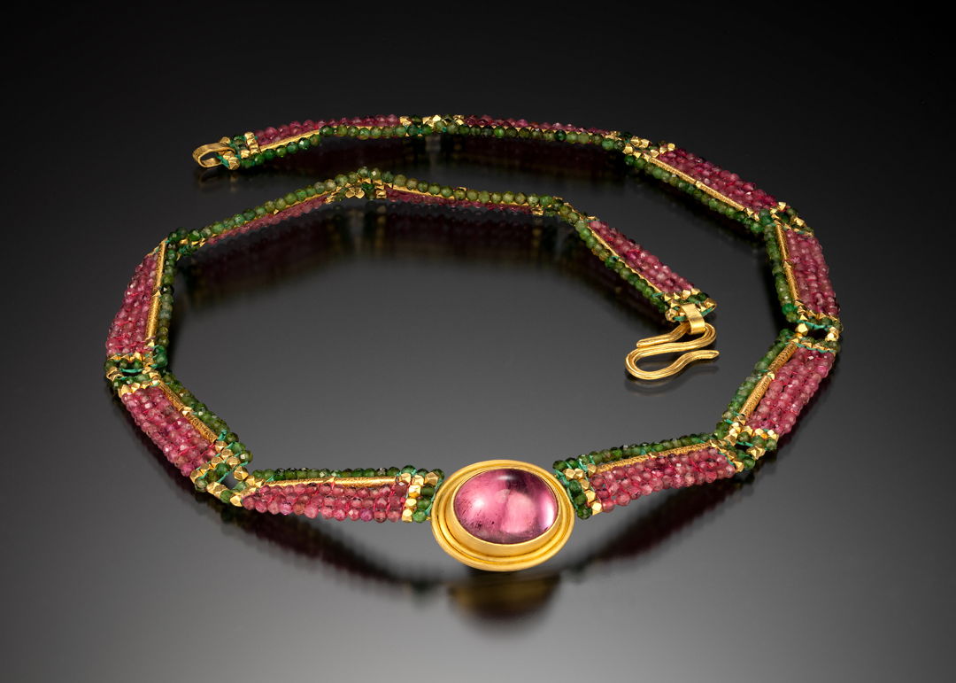 Collar  hand woven with pink and green tourmaline  and 20 k gold beads. Bezel  hand fabricated (fused) with 22k gold and set with a brilliant pink tourmaline cabochon.