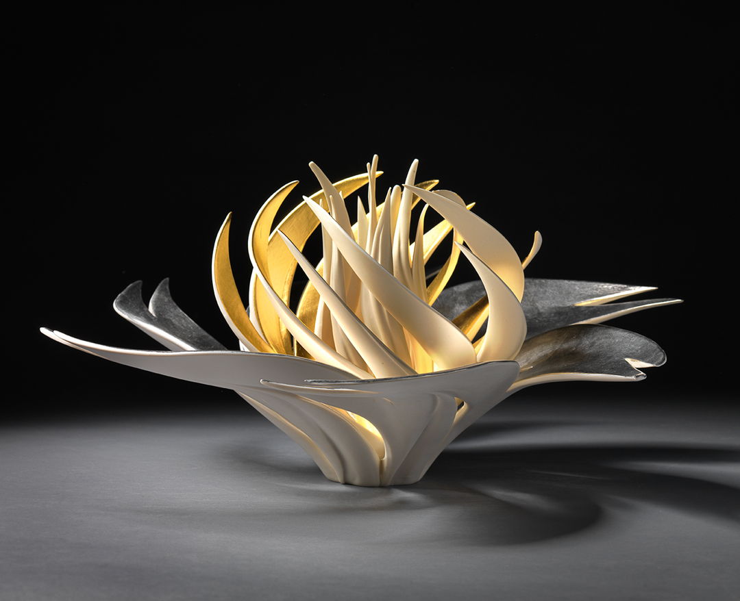 Porcelain that has been carved. Interior is gold gilded.