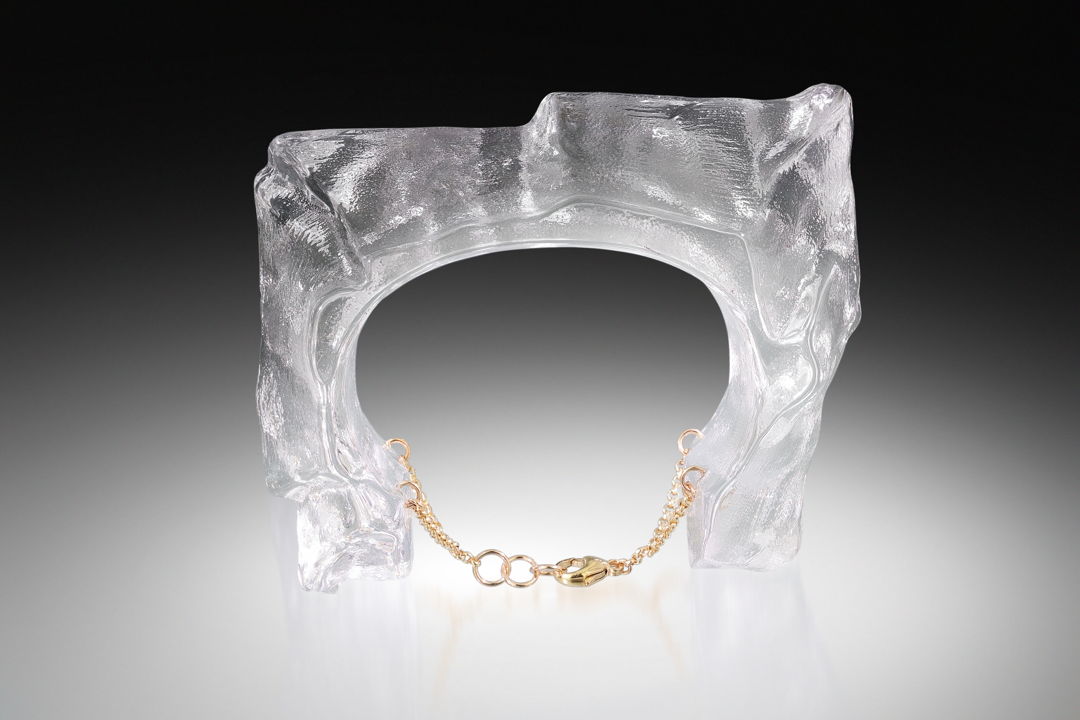 Digitally Designed Form  Hot Cast into 2 part steel mold  coldworked and laminated. Gold Fill Findings are embedded into the glass and attached to a gold fill chain for securing the piece to the arm