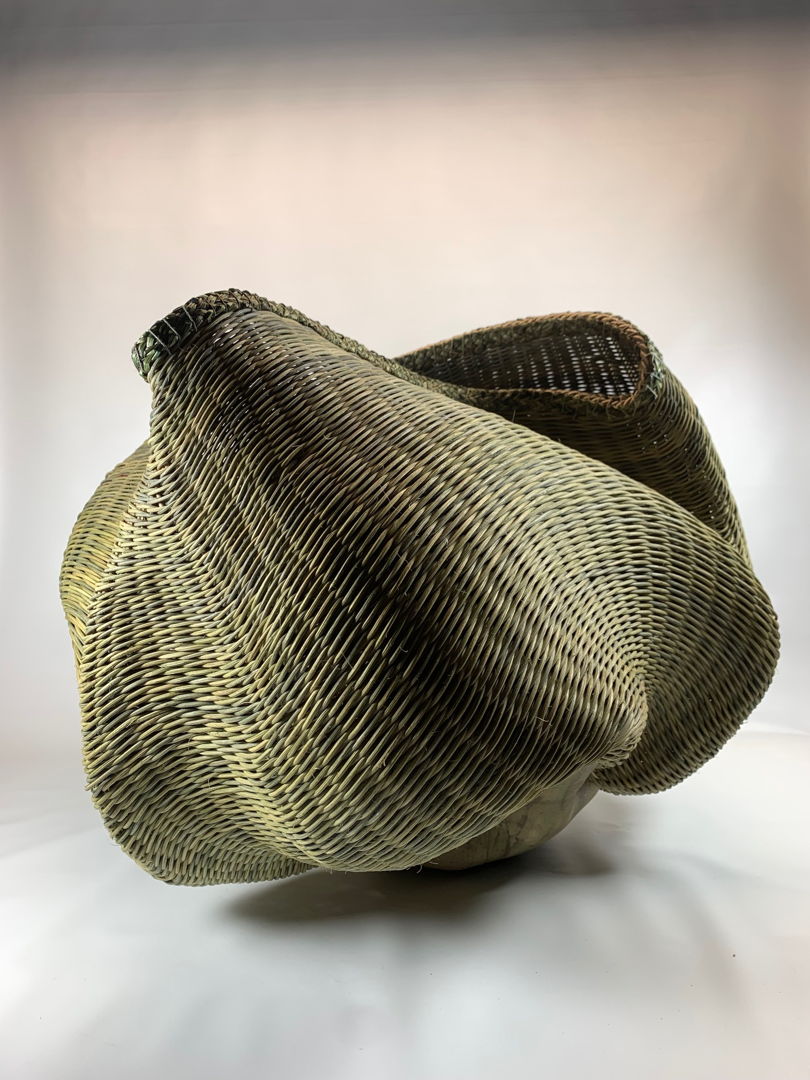 Hand-built pottery woven with dyed reed.