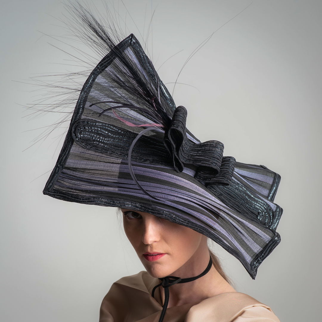 The base square piece of this hat is a natural fiber called Buntal. I cut it into a 16 inch square  and stitched wire at the edge  then stitching Swiss Raffia braid over the both sides of the wire. The center strip and the half crown base I created from 11 mm horsehair braid and accented.