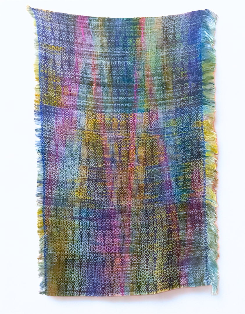 Hand painted and hand dyed tencel yarn handwoven in original design in a modern ikat style to create weft pooling. Colors and design inspired by the Green Breasted mango bird.