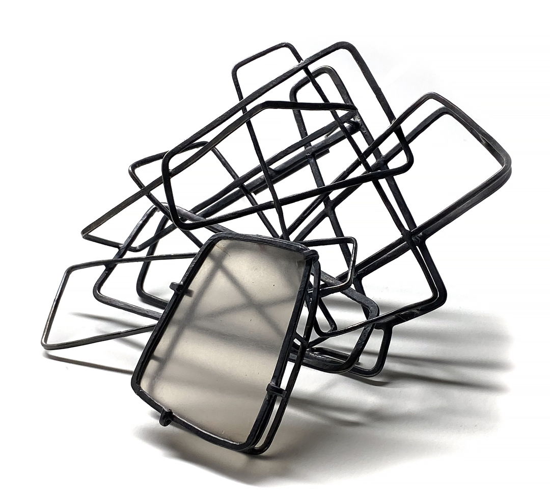 Hand made oxidized sterling silver chain is manipulated to form the three dimensional structure of line. The sandblasted mica is set within the brooch creating a focus for the relationship to light  space and shadow. (One of a Kind)