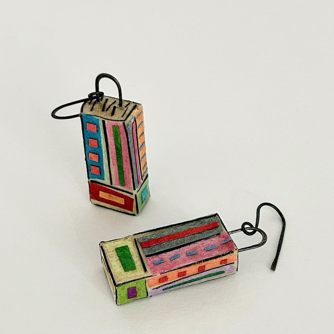 The detailed and unique patterns on these earrings remind the artist of tapestries  thus their name. Tapestry Earrings are hollow 3-dimensional rectangular-shaped earrings with hammered annealed steel curved dangles. Mat board is used to create the rectangular structures  with layers of various papers “painted” on with brush &amp; glue for both base colors and patterns. The earrings are sealed for use.
