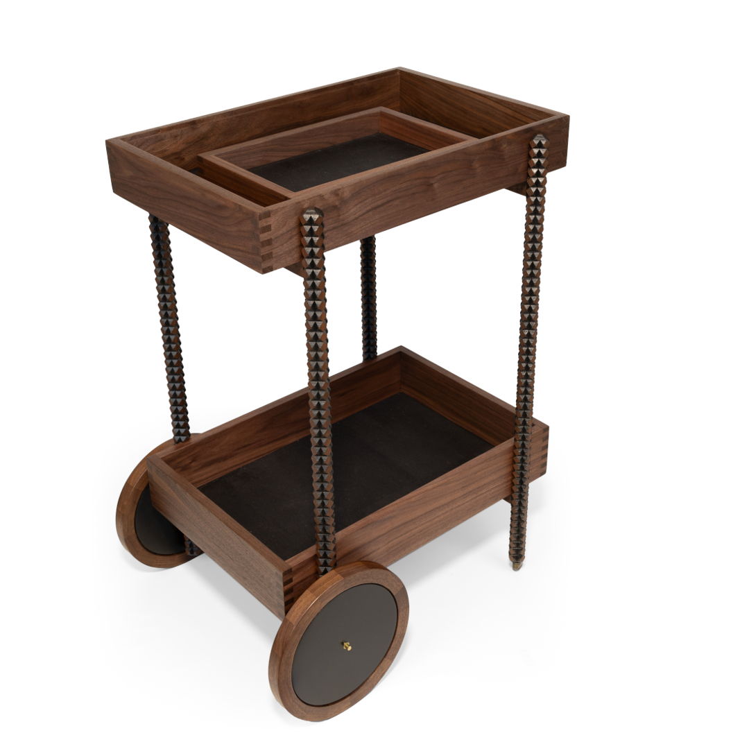 this bar cart features coopered wheels and bandsaw carved legs with black accents. the bottoms of each finger-jointed box are lined with black cork. the top tray is removable for easy serving. a bandsaw carved handle on top box and little brass wheels on the front makes for easy maneuvering