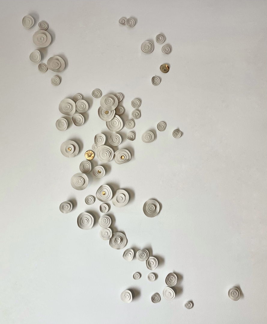 Wall with thin porcelain circles. Gold luster applied on some.