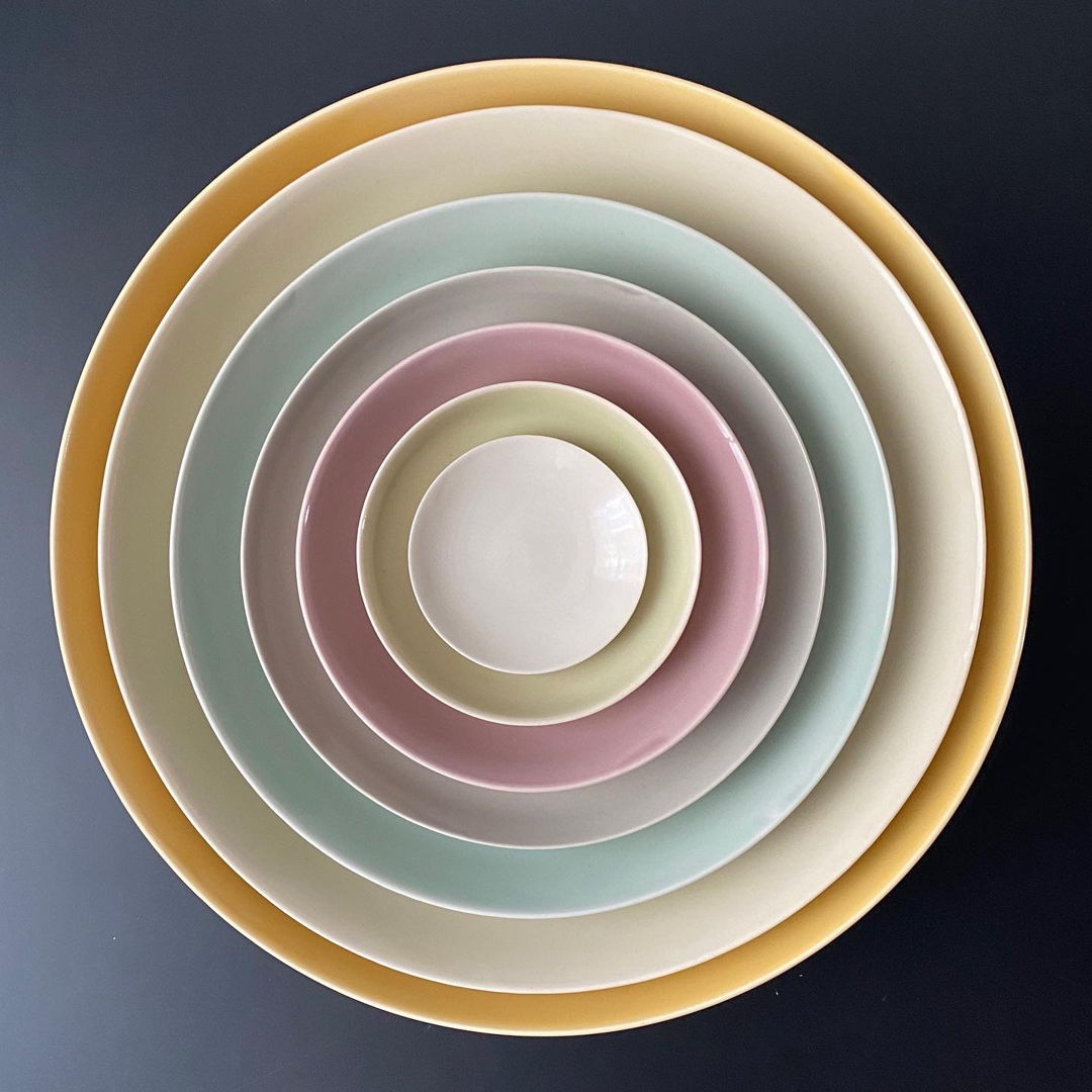 Set of nesting bowls, each with a different glaze color, making up a pastel rainbow