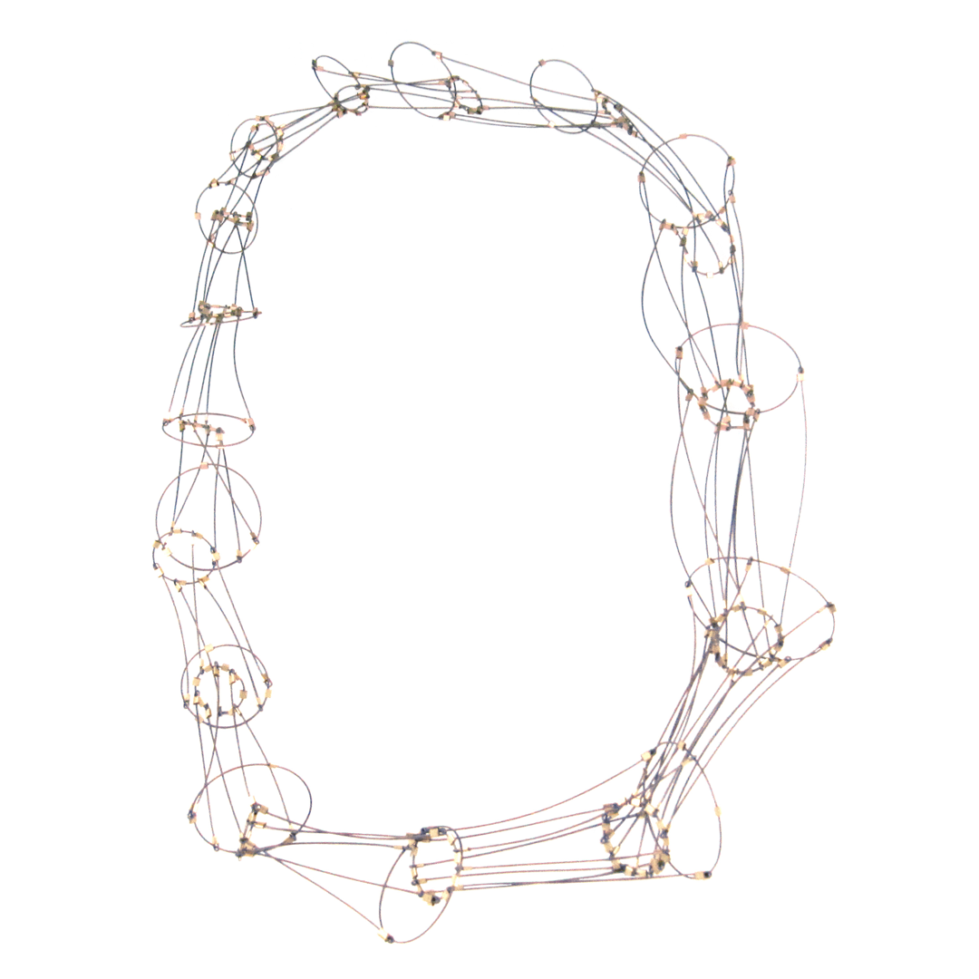 Graduated cones of interlocking nylon-coated steel finished with 14k gold fill tubing. The neckpiece is soft and pliable  conforming to the body when worn.