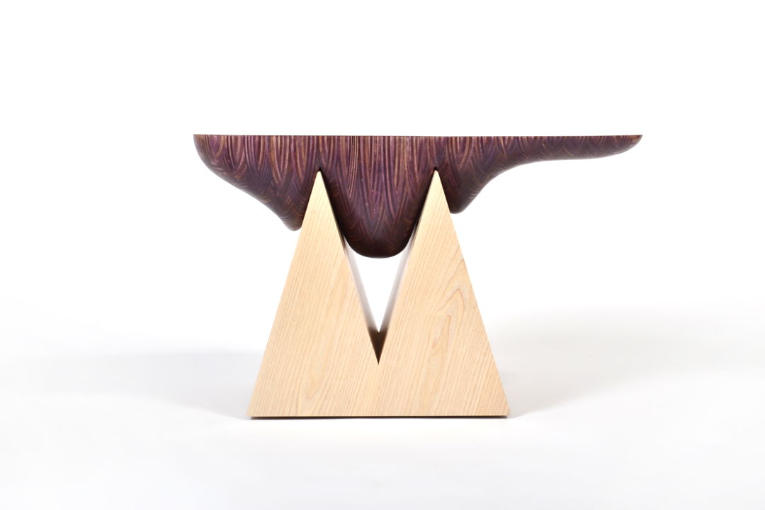 Inspired by the naturally formed beauty of geodes  this side table combines our Nerikomi wood with a solid ash wood base. The Nerikomi wood top was hand sculpted to nest onto the top of the geometric triangular wood base.
