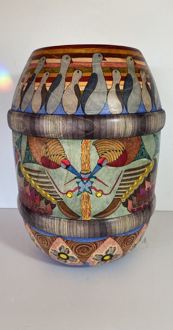 This barrel shaped vessel came from sassafras wood. The middle surface design was created directly onto the surface without any preparatory pencil marks  lending the process a free range for my imagination. The upper and lower portions were designed using pencil lines beforehand to support relative uniformity of the repeats. This design focuses on the intersection between outer life and inner life