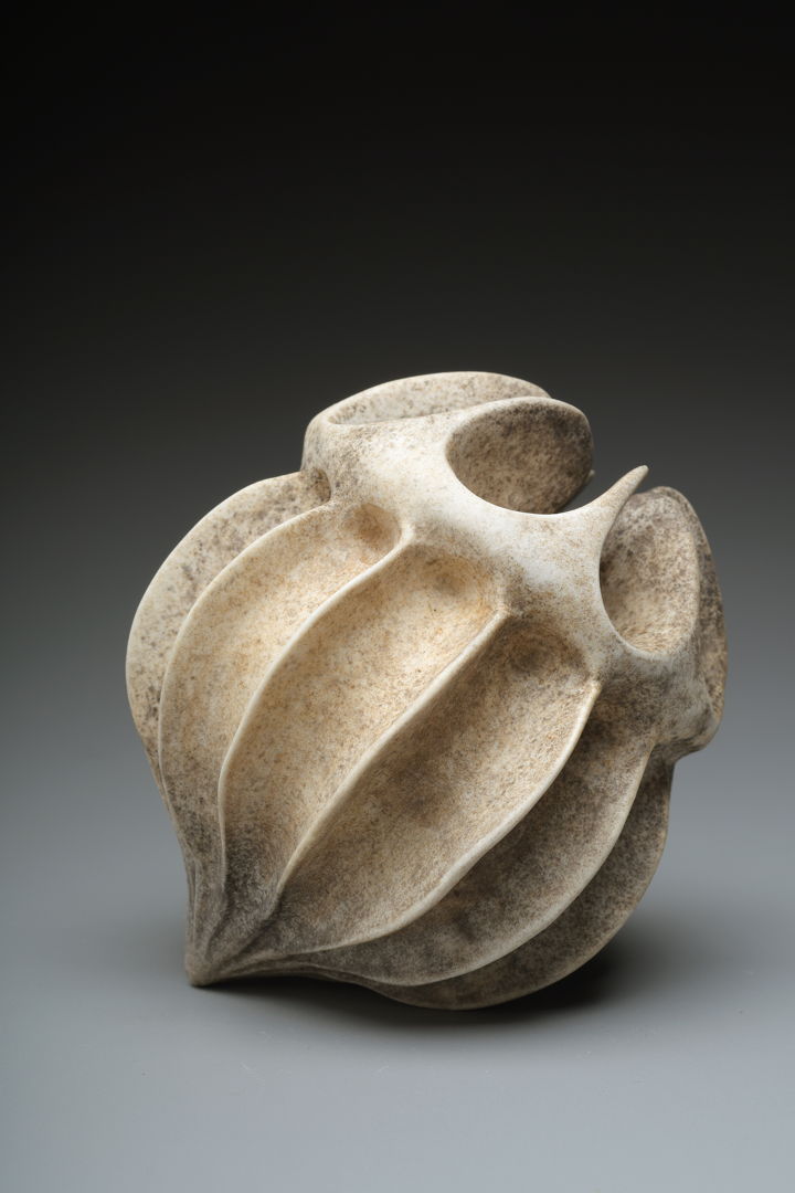 Porcelain form resembling a seed pod with rough grimey exterior.