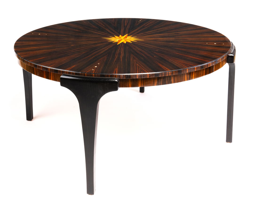 This elegant coffee table is made in the Art Deco style. The tabletop is Macassar ebony in a pie-matched pattern with Mother of Pearl inlay. An inlaid 16-point compass rose adorns the center. Legs are ebonized ash. A polished piano finish enhances the beautiful colors of this wood.
