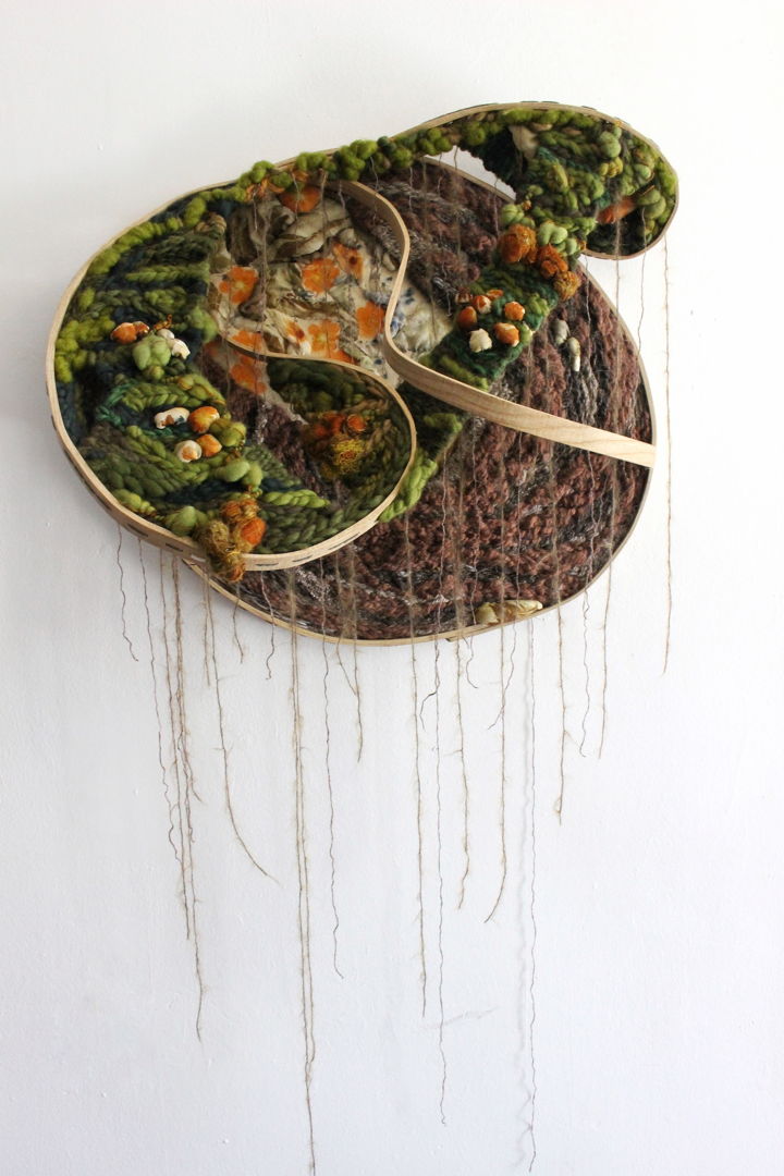 Interdependence is the reliance of two or more things on one another. In this piece the botanically dyed cloth is moving in to the woven areas  further integrating itself into the system. There background is hand stitched  and amalgamation of prints from various plants coming together to create a visual field in conversation with the woven planes. The bent wood frame is highlighted as a visual element in addition to framing and supporting the piece.