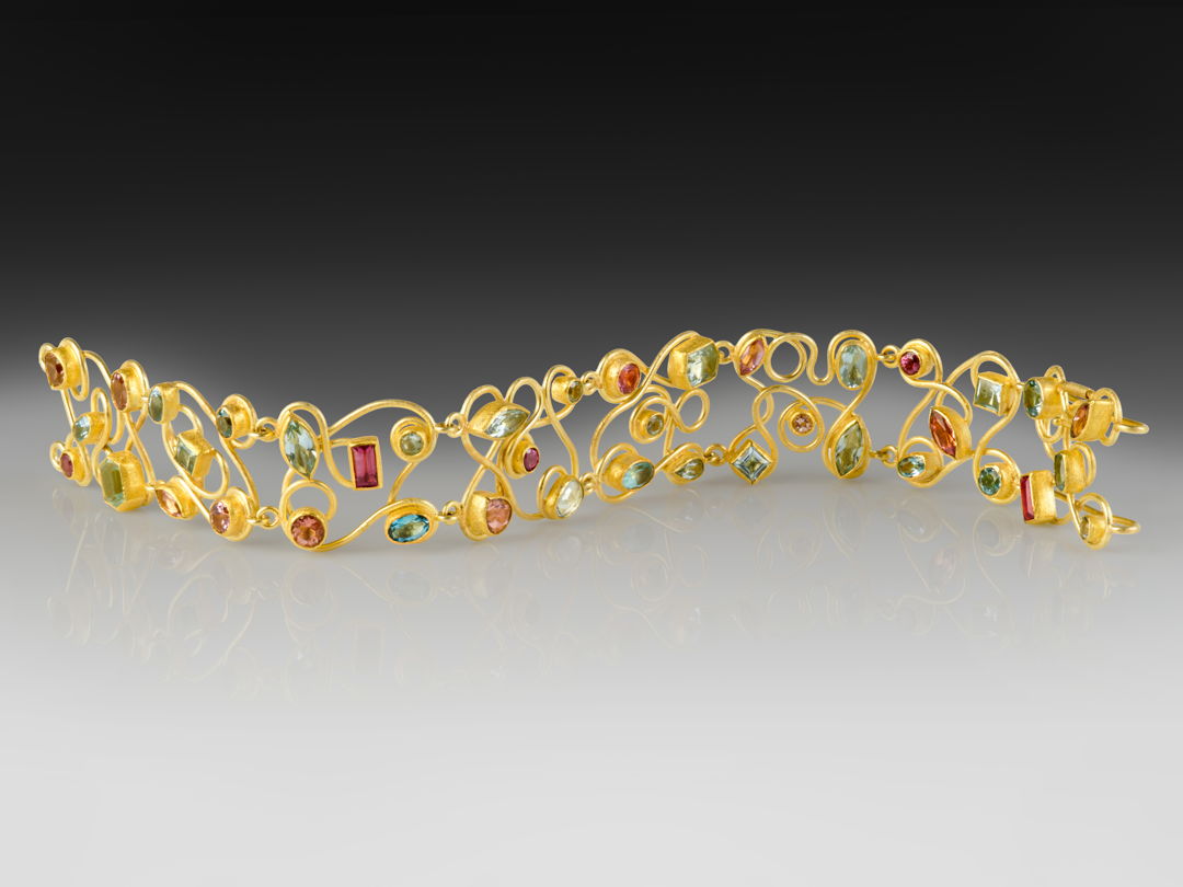 Mixed cut and shape aquamarines and pink tourmalines (14.45ct total) set in 22k gold bezels with 18k backing  swirl design and safety clasp.