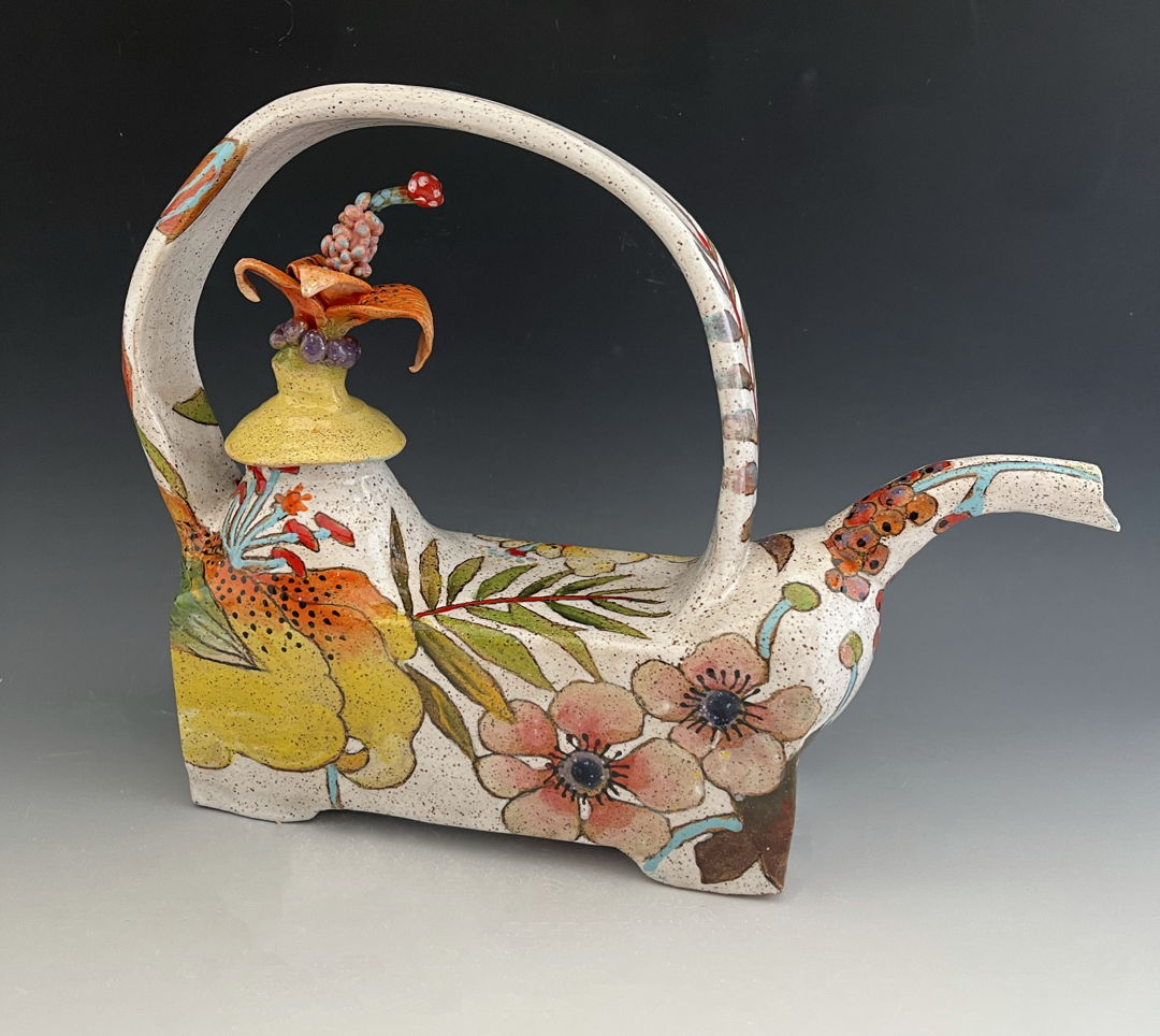 Teapot made with a combination of hand-building and wheel-throwing techniques with painterly glaze and under glaze decoration of flowers. Lid has small flower sculpture.