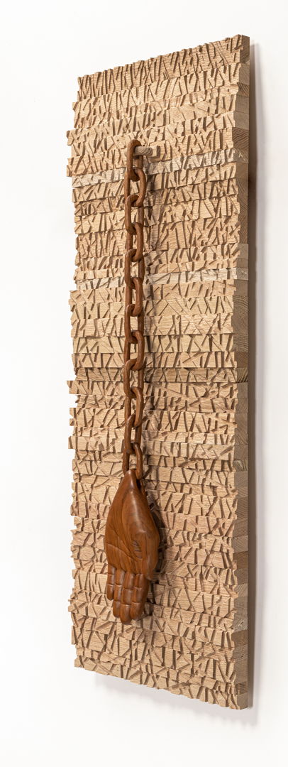 (2020) Materials: Red oak (background)  Weeping Cherry (hand and chain).