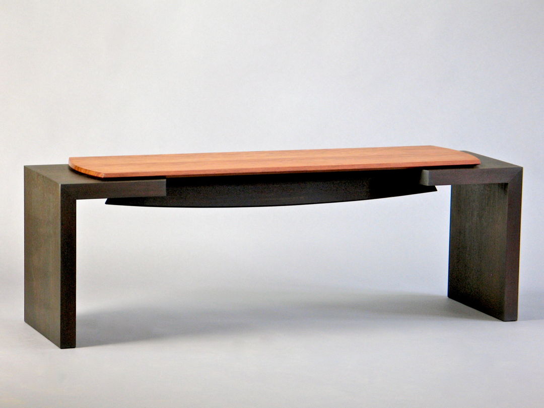 Ebonized solid walnut base with a sculpted and bowed stretcher supporting a floating seat made of solid figured bubinga.