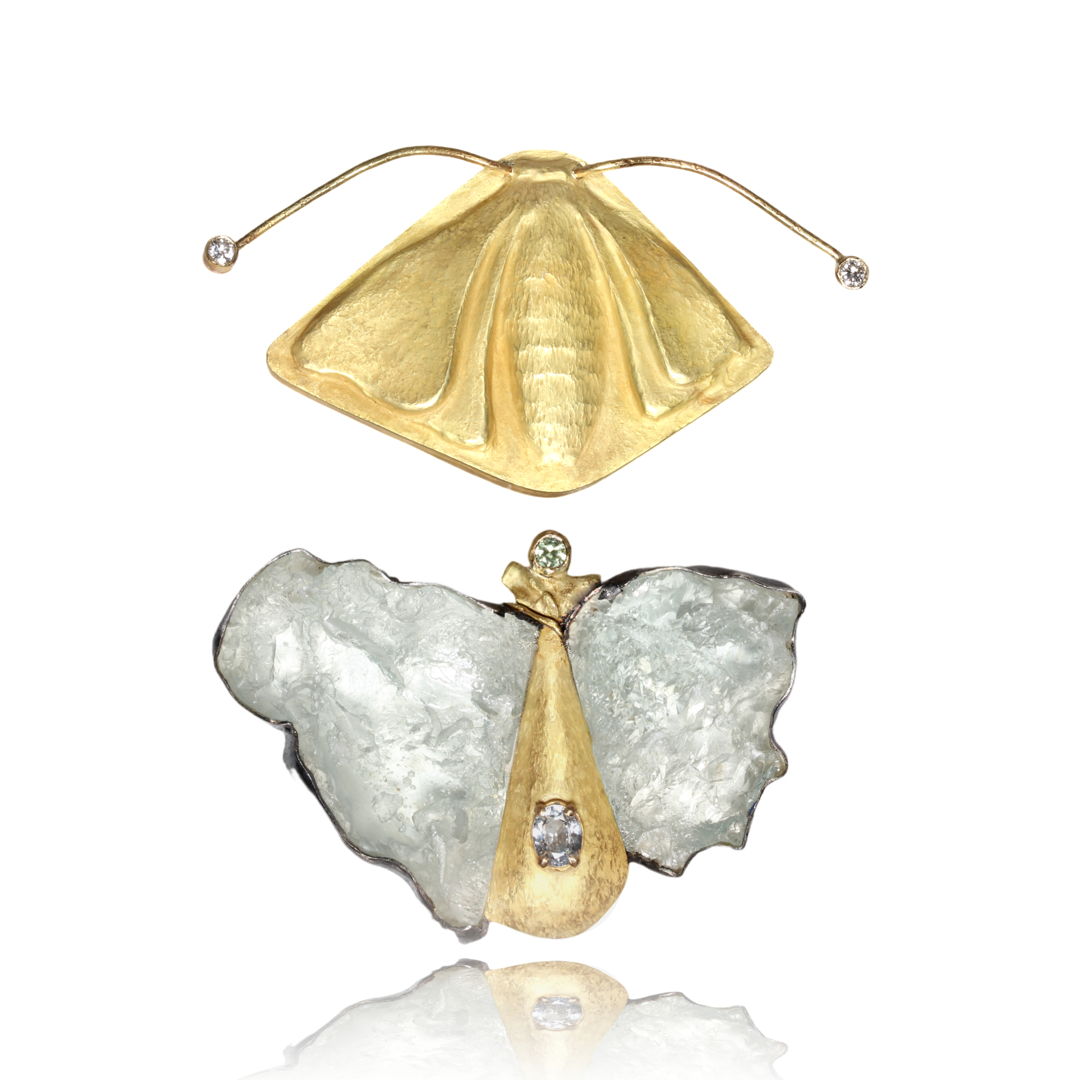 This 2 part brooch has a repousse gold silk moth on the top with diamonds at the end of each antennae. The bottom brooch expresses the light  airiness of a moth. This part is made up of 2 aquamarine crystals set in silver on either side of the gold body which is set with sapphires.