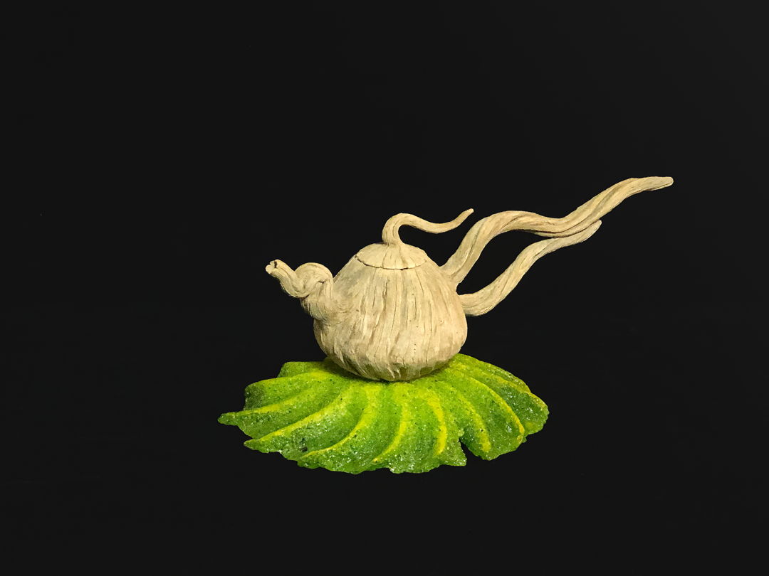 Hand carved ceramic teapot on cast glass base