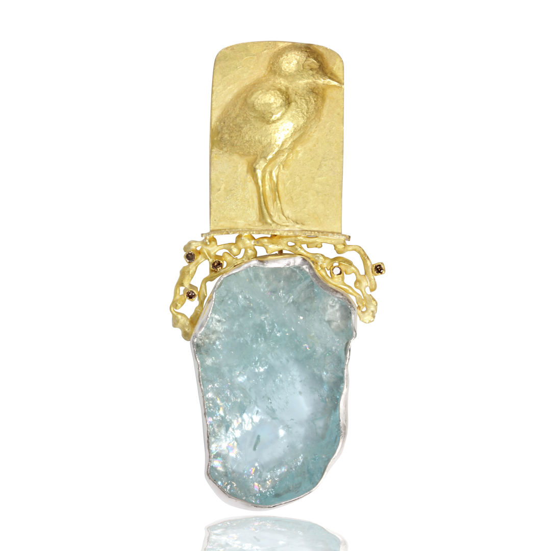 The gold repousse sandpiper is standing on fused textures beach with little diamonds  . The aquamarine representing water  I cut   is set in silver