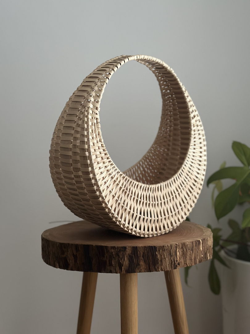 Cresent-shaped basket with light wood weave