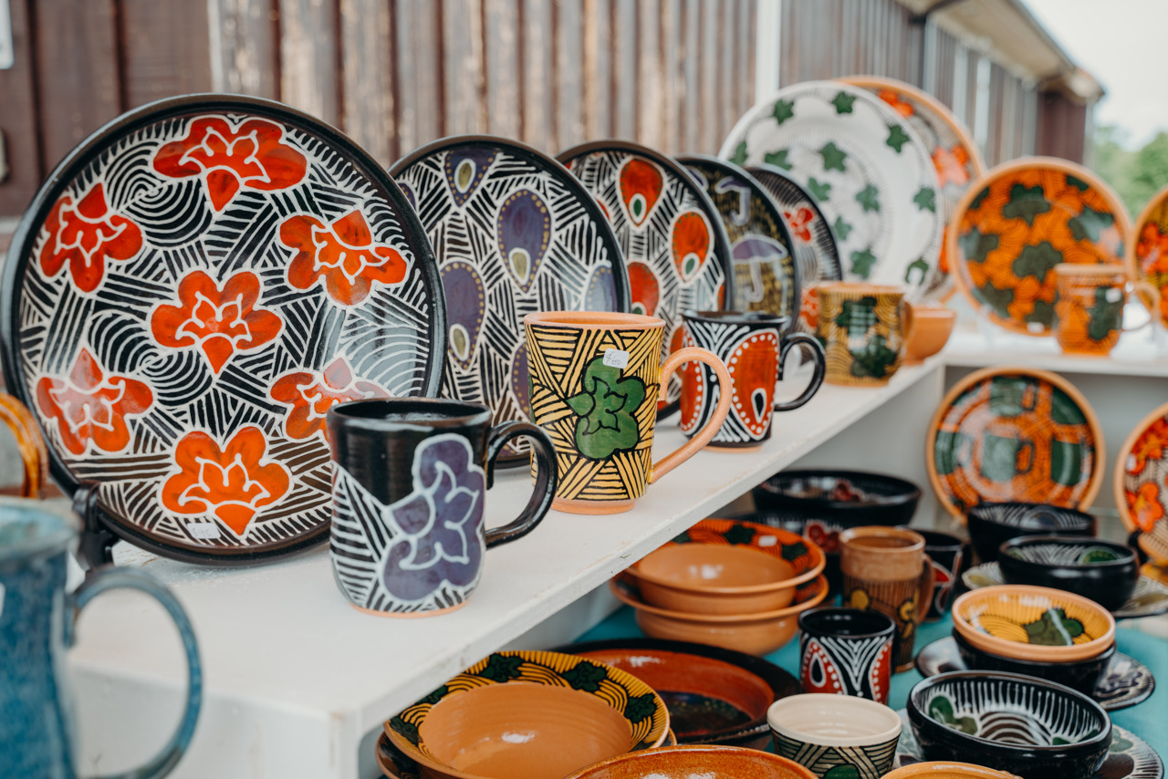shelf full of colorful plates and mugs