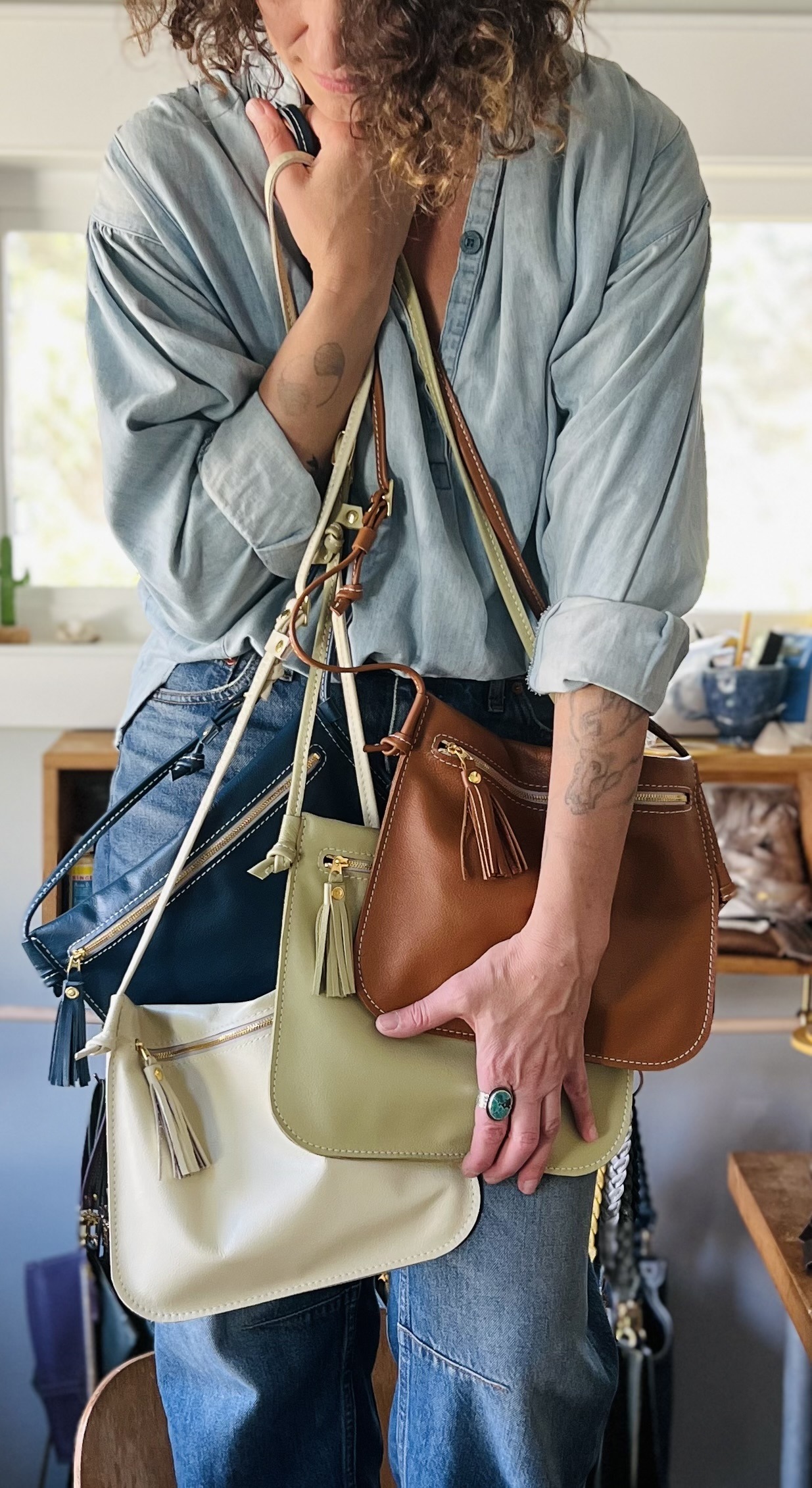 model holding a leather bags in a range of colors