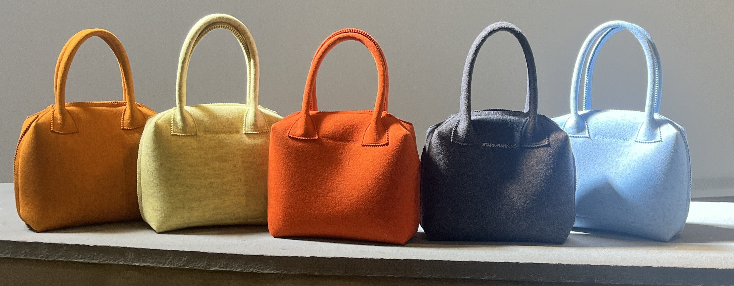 a row of colorful felt bags