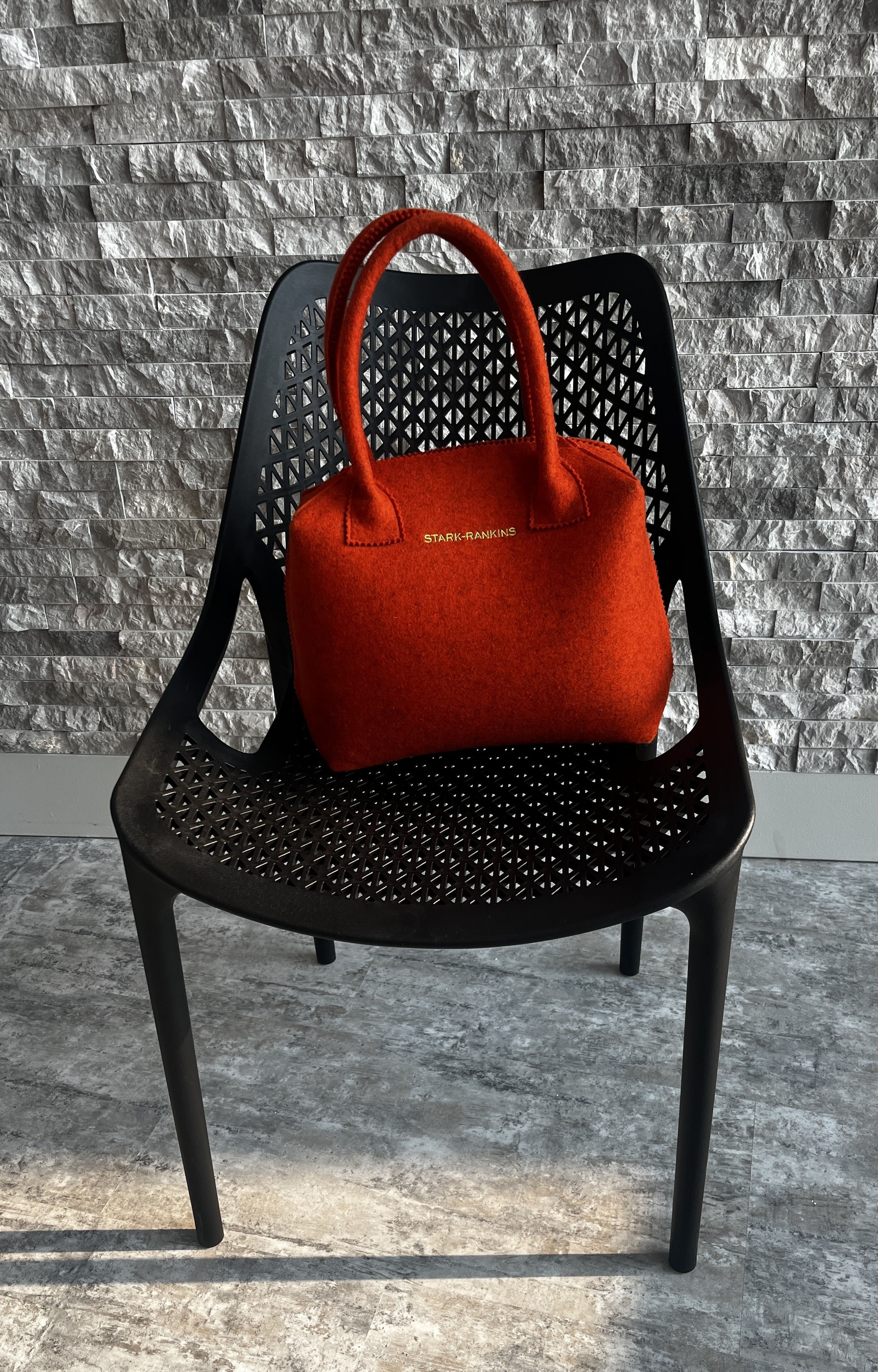 orange felt bag on a chair