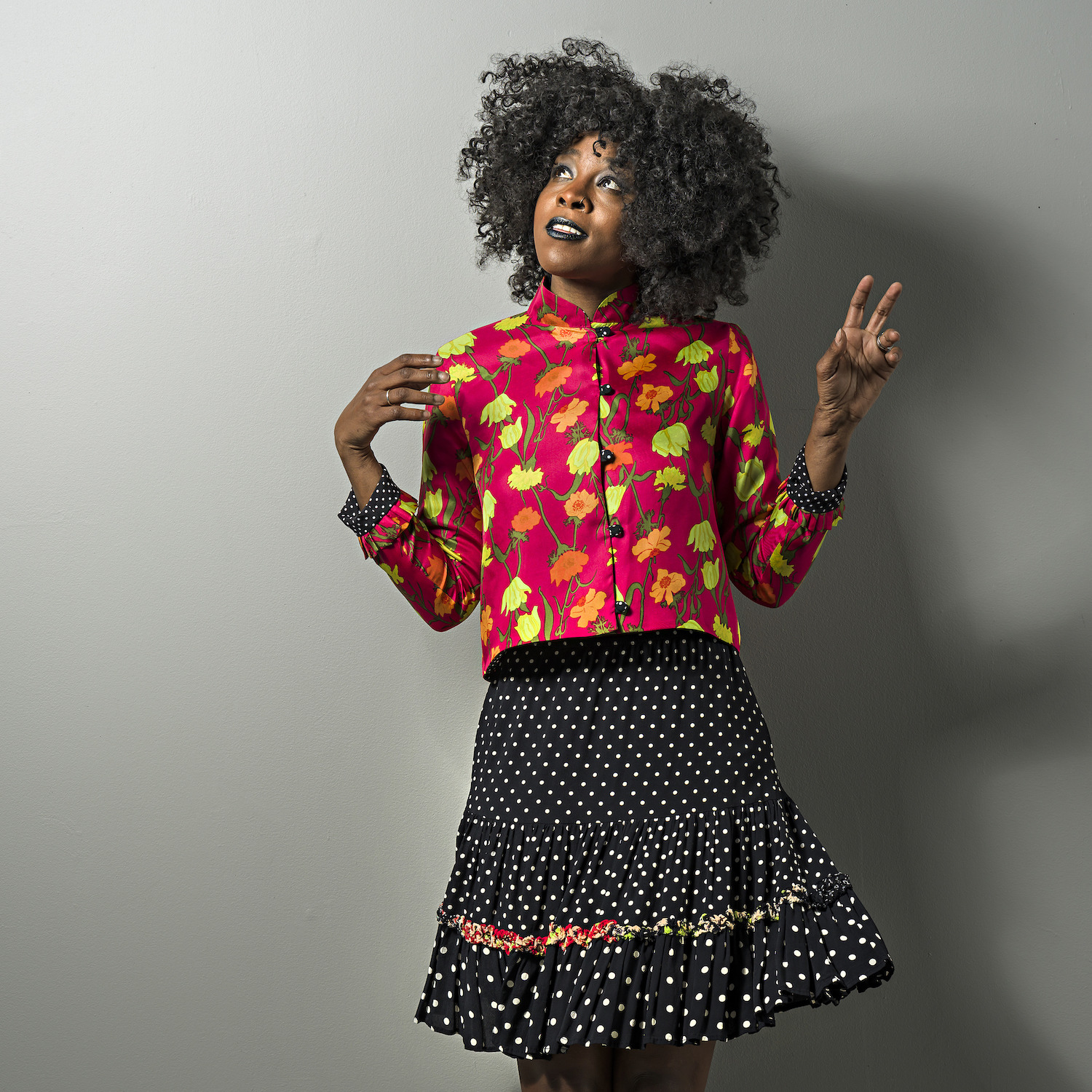 model with short floral jacket and polka-dot skirt