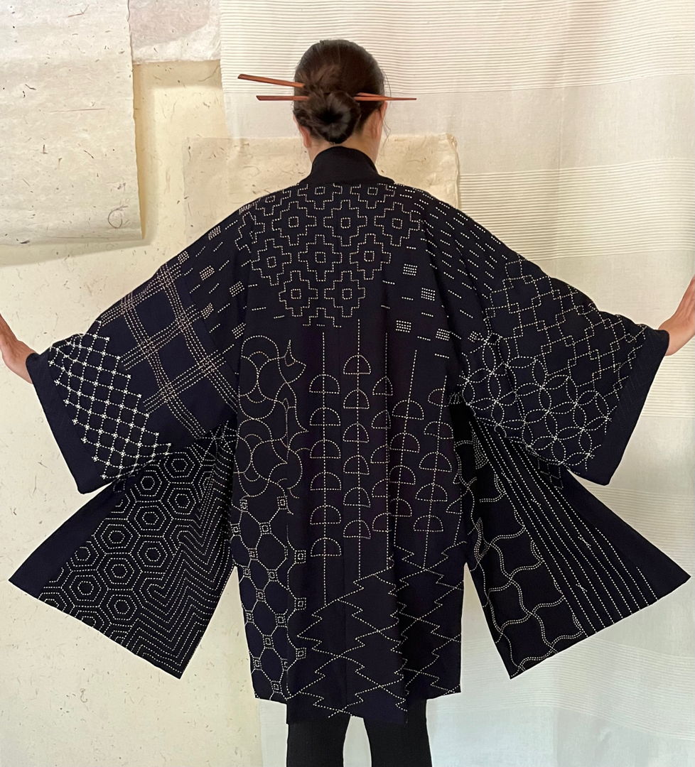 Each time I create this piece  I take my feelings of the moment to generate originality. Each pattern meets another in an asymmetrical way  creating an exciting puzzle for the eye. The fabric was dipped 60 times in natural indigo plant dye  with thread dyed from chestnut  onion  and other plants.