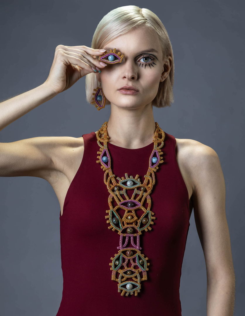 Created in the occasion of the art exhibit at NYCJW 2023  "A history of revolutions"  curated by the Ilias Lalaounis Jewelry Musuem. This jewelry set with necklace and earrings is inspired by traditional Greek chest ornaments  and refers to the Social Media revolution. The neckpiece measures 30 inches in length and it comes with a sturdy magnetic closure. Handwoven with fine Japanese seed beads  24K gold plated beads  and semi precious stones. Earrings with aquamarine stones are matching the neckpiece.