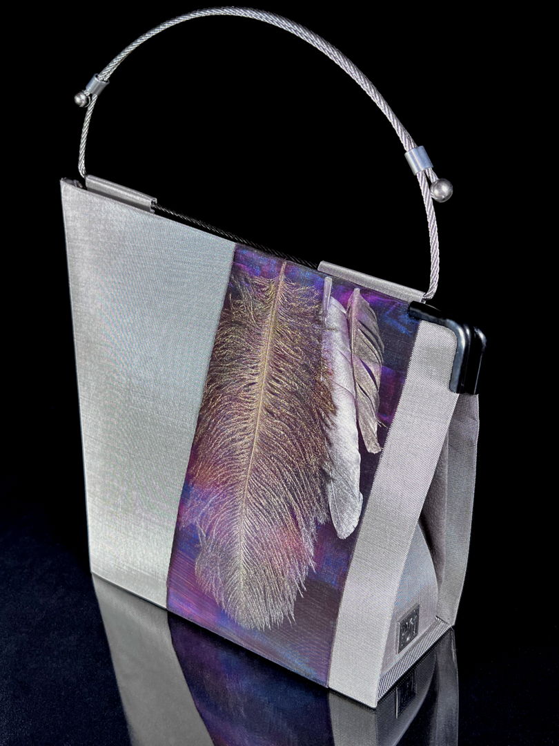 Handbag made of stainless steel mesh decorated with natural feathers. Adjustable handle made of aircraft cable