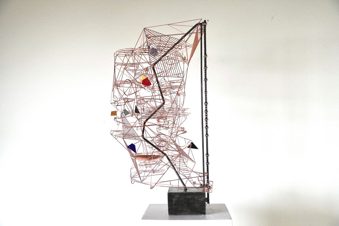 Copper wire and steel motorised kinetic sculpture. The sculpture is activated by a chain that lifts steel marbles to the top of the piece. The marbles roll down the sculpture on one of three paths and interact with nine moving elements. Kiln-fired enamelled copper parts function as counterweights.