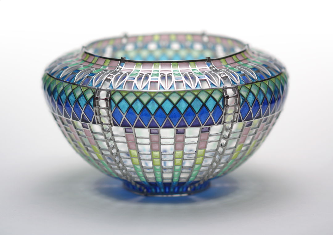 Materials: Enamel  sterling silver. Technique: Plique a Jour-- I construct a sterling framework  then fill openings with enamel powders and fire in furnace until it fuses to the silver. This is repeated until the openings are filled. Surface tension keeps the molten glass in place during firing.