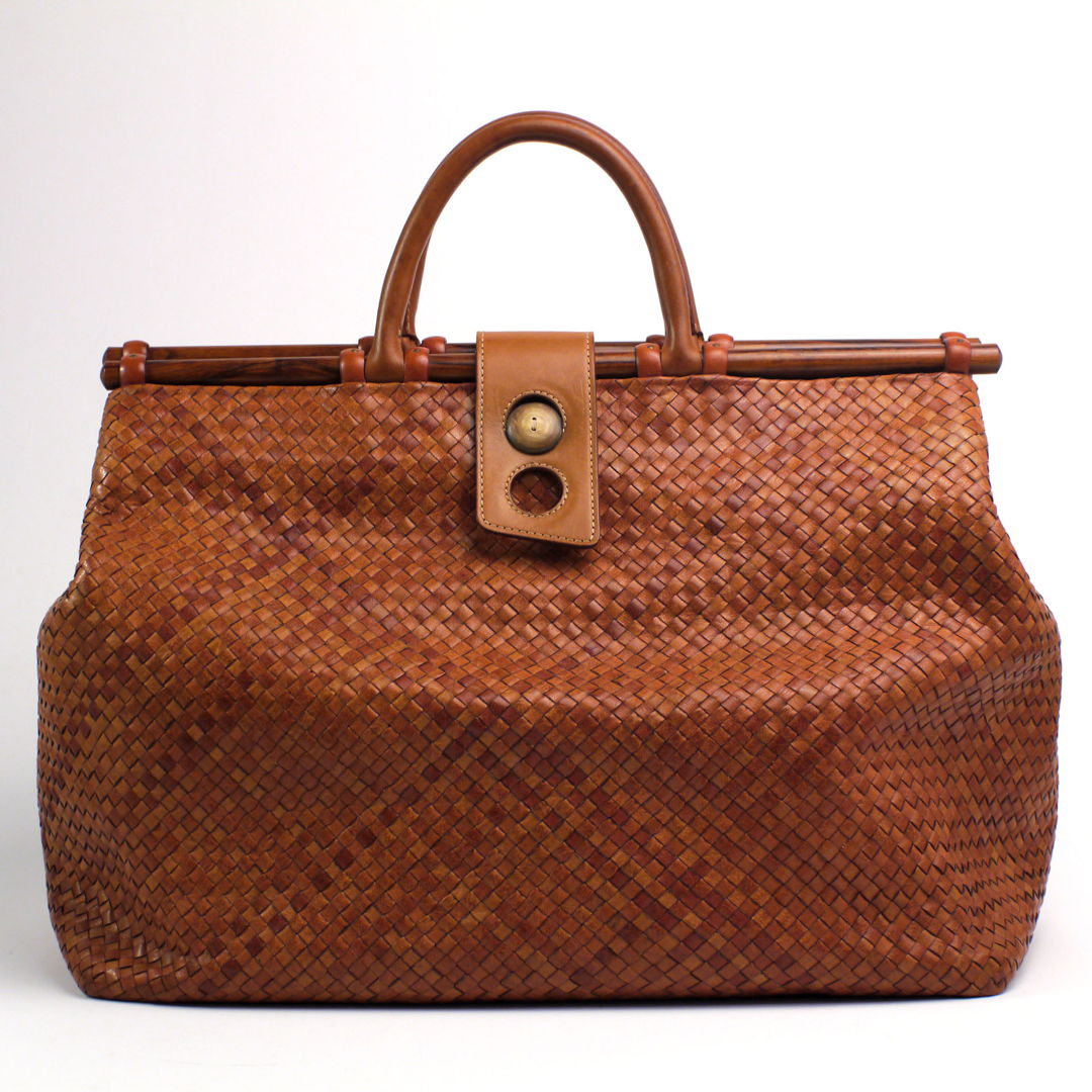 This purse was handwoven from individually handcut  edge-thinned and edge-dyed 1/4 inch water buffalo calfskin leather strips the traditional way for a seamless finish. Provided with leather lining that is fused and laminated to the woven part  cocobolo dowels and water buffalo horn button.