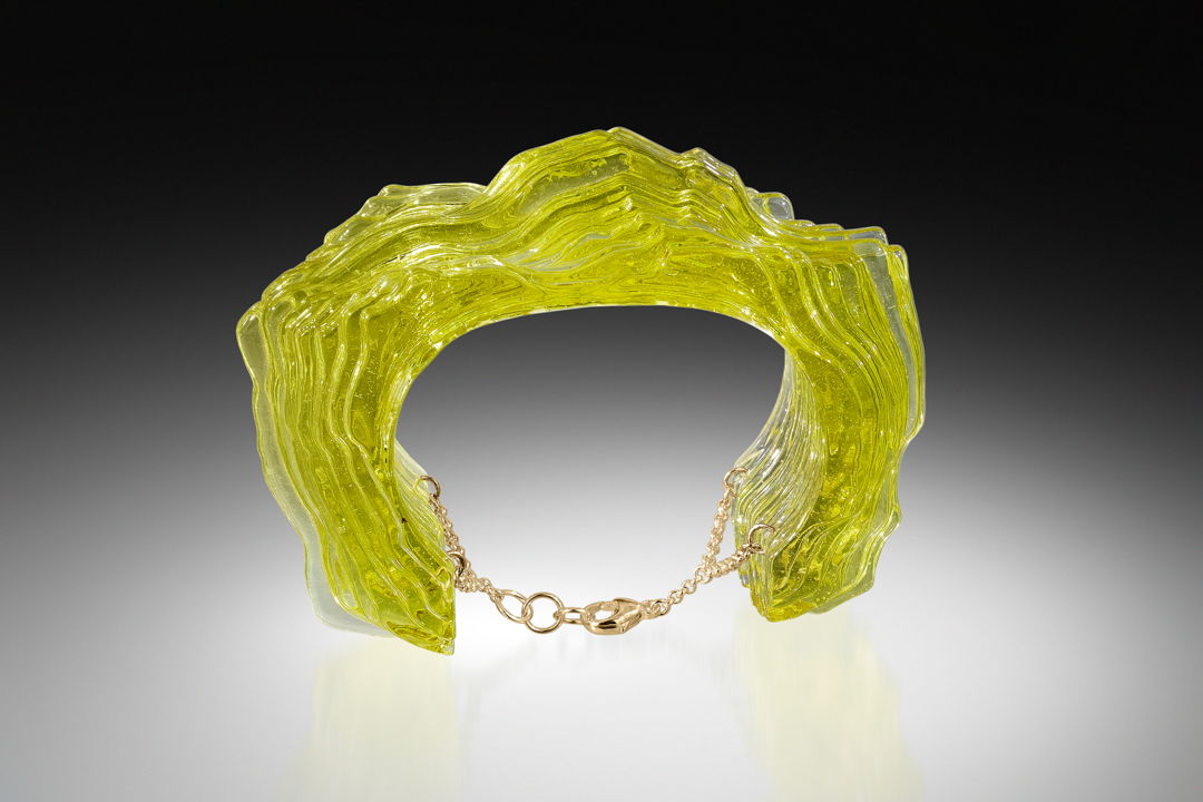 Digitally Designed  waterjet cut glass  coldworked  polished  fused and laminated together to form a 3 dimensional glass form. Gold Fill findings are embedded into the glass and attached to a gold fill chain for securing the piece on the arm.