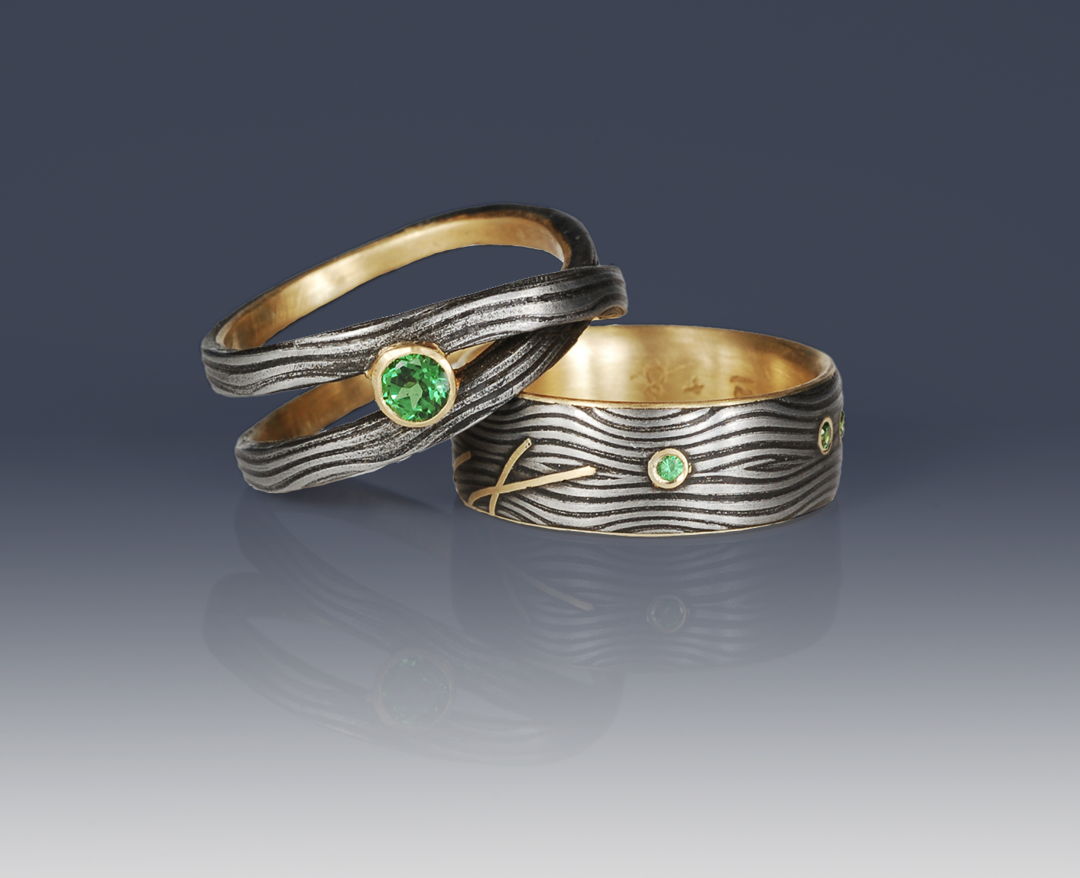 Housemade Damascus steel rings with 18K gold interiors and accents. Tsavorite garnets