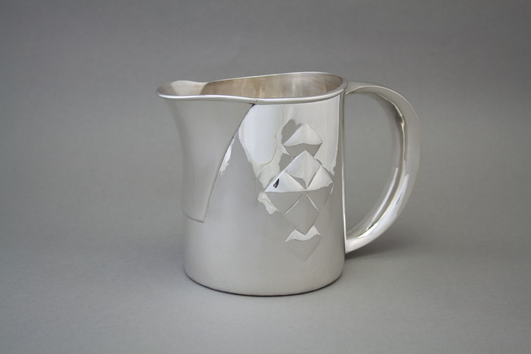 Hand Raised Sterling Silver Pitcher featuring a hollow silver handle and hand-chased decoration.