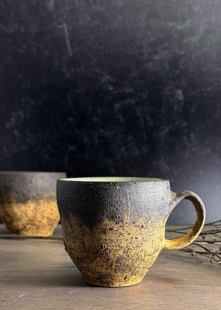Golden sands mugs are thrown from a dark red clay body and decorated with a blend of wild clay slips  sand  volcanic ash from Iceland's Katla volcano  and underglaze. Inspired by Iceland’s Skarðsvík Golden Beach with its sparkling sands and browned basalt columns.
