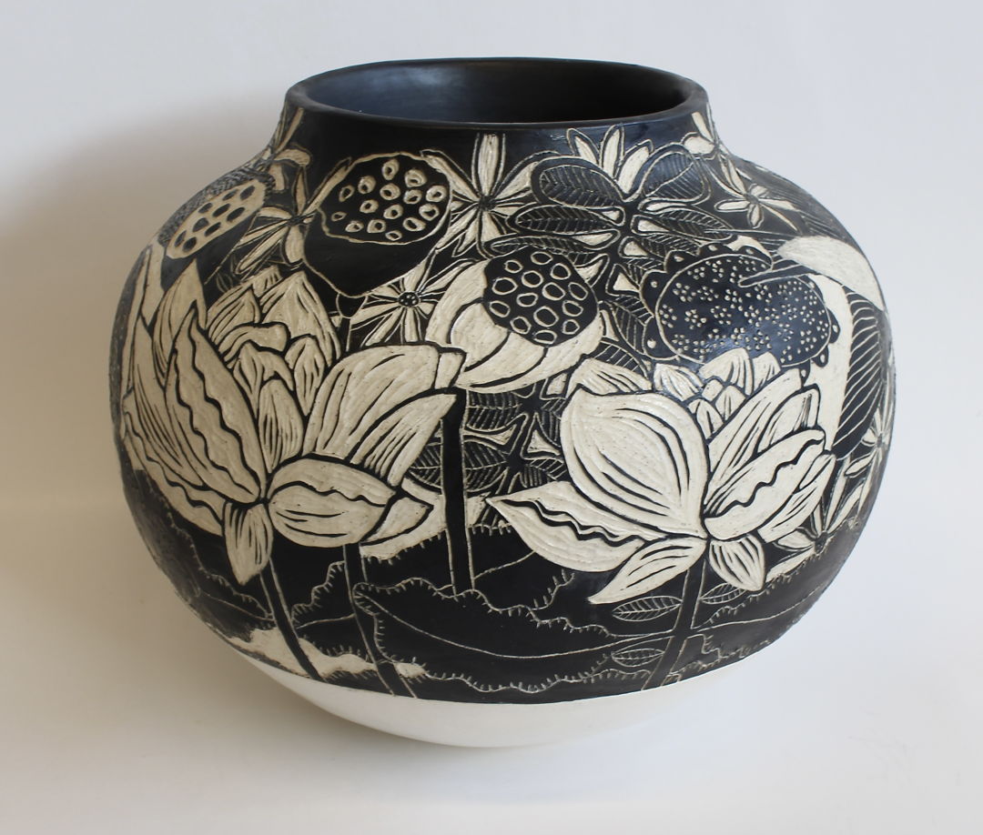 The images on the surface of the pot were created using sgraffito and depict a pond that includes flowers  insects  and birds. The lower portion of the pot is glazed with satin white glaze.