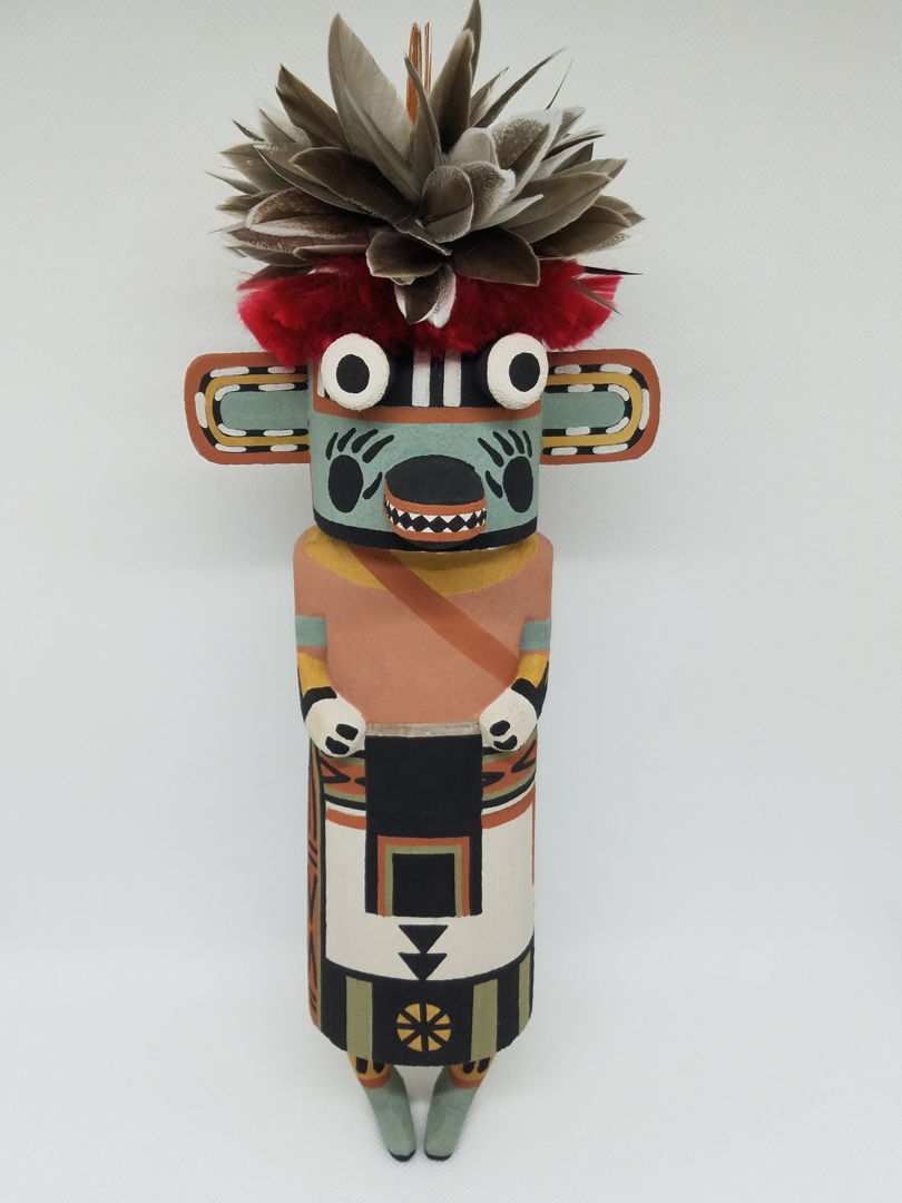 Carved from cottonwood root  painted with natural earth pigment paints. Other materials used  duck feathers and natural dyed goat hair.