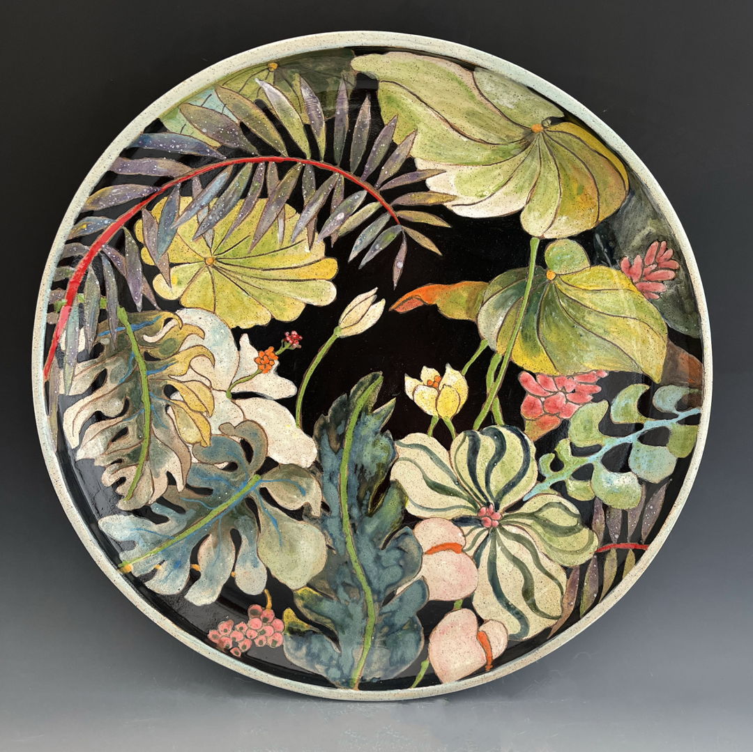 Plate made with a combination of hand-building and wheel-throwing techniques with painterly glaze and under glaze decoration of leaves and flowers.