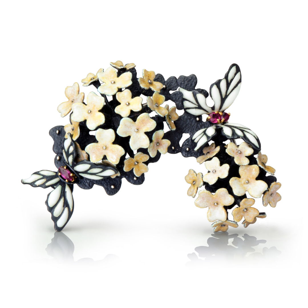 kiln fired enamel petals form two 3-dimensional hydrangeas. Two butterflies with textured enamel wings and rubies. The composition of the hydrangeas and butterflies is very sculptural and poetic.