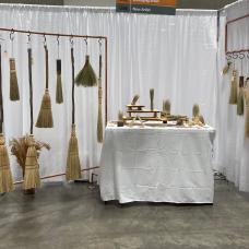 A collection of large and small brooms and brushes from a marketplace show in fall 2022.